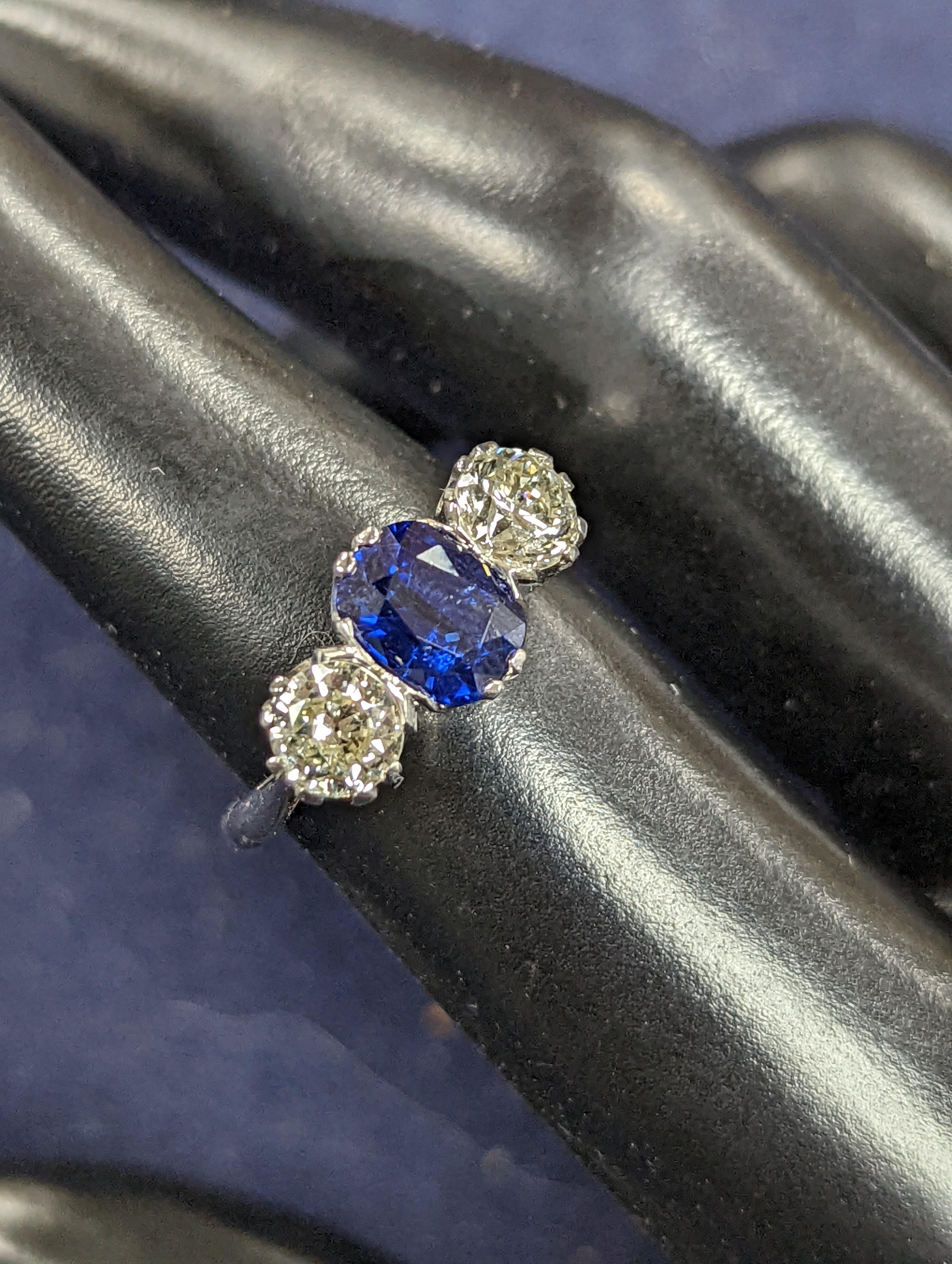 A modern 18ct white gold, single stone sapphire and two stone diamond set ring, size L, gross weight 4.2 grams